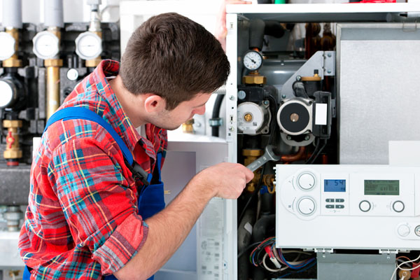 HVAC technician inspecting and repairing boiler controls in Castle Rock