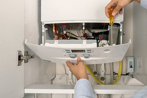 HVAC technician repairing an indoor boiler in Castle Rock