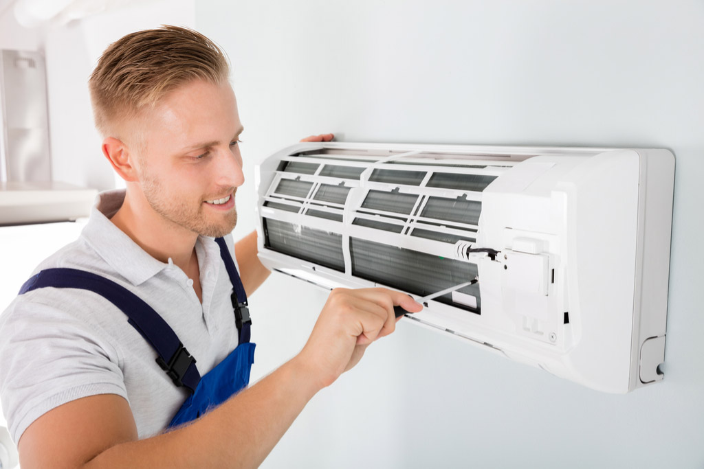 HVAC technician performing ductless air conditioning maintenance in Castle Rock