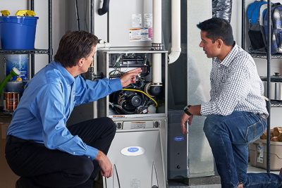 HVAC technician explaining furnace repair and maintenance to a homeowner in Castle Rock, CO
