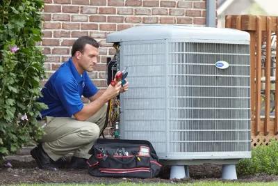 HVAC technician inspecting an outdoor air conditioning unit in Castle Rock, CO