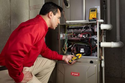 Heating and air conditioning technician servicing an indoor furnace in Castle Rock, CO